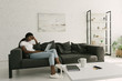 © LIGHTFIELD STUDIOS - thoughtful african american freelancer sitting on sofa with laptop in spacious living room