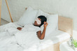 © LIGHTFIELD STUDIOS - young african american woman sleeping on white bedding in sleep mask