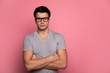 © My Ocean studio - Smart and strong.Close-up photo of a handsome man in a grey t-shirt and glasses, who is looking in the camera while standing with folded arms.