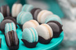 Light cream, tiffany blue and chocolate macaroons on tiffany blue stand. Food knolling concept