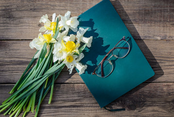 Poster - White and yellow daffodils, book and glasses on a wooden background