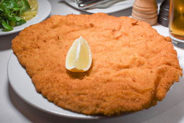 Wiener schnitzel, veal cutlet, austrian cuisine. Served with cold potatoes and rucola salad