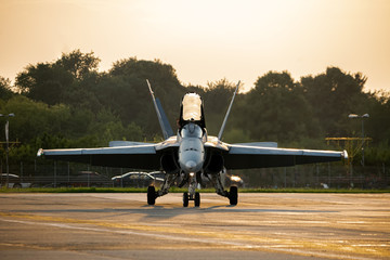 Army fighter airplane with open cockpit. Military navy pilot waving after landing in beautiful sunset light