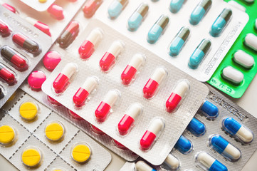 A lot of Colorful Medicine pills, tablets and capsules in packaging.