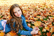 © svetamart - Autumn portrait of adorable smiling little girl child preteen lying in leaves in the park
