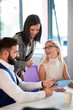 © luckybusiness - Office colleagues smiling while discussing business