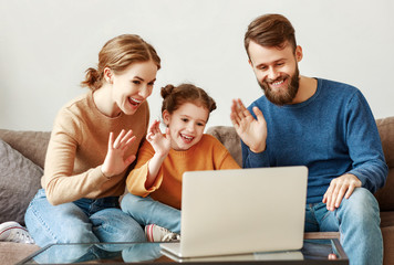 Happy family chatting online via laptop together