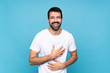 © luismolinero - Young man with beard  over isolated blue background smiling a lot