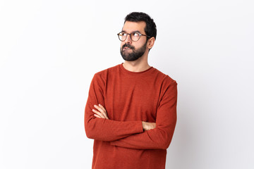 Wall Mural - Caucasian handsome man with beard over isolated white background with confuse face expression