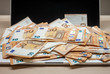© chechotkin - open laptop and pile of money euro banknotes