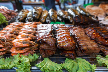 .Grilled and delicious seafood and meat arrangement on a counter in Thai restaurant. Barbecue srimps prawns. Thailand, Ko Pha Ngan