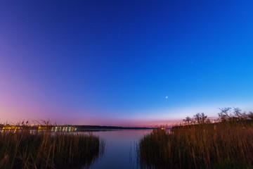 Wall Mural - charming landscape on the river at sunset and night time
