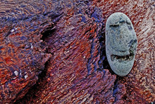 Close-up Of Anthropomorphic Face Carved On Pebble At Beach