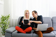 © Angelov - Young couple relaxing on sofa with digital tablet and laptop.
