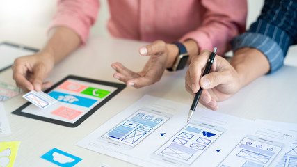 Team User experience (UX) designer creative graphic planning or designing application development a prototype for mobile phone or smartphone layout.