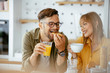 © JustLife - Young couple making breakfast at home. Loving couple eating together