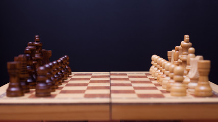 A game of chess, the beginning of a chess game two sides opposite each other.