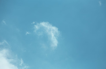 Fluffy clouds cover the summer blue sky