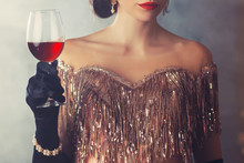 Closeup Silhouette Elegant Flapper Woman Holding In Hand Glass Of Wine. Holiday Makeup Retro Red Lips, Sexy Mouth, Vintage Style 20s Roar Gold Evening Dress. Mysterious Cropped Portrait Head, Face