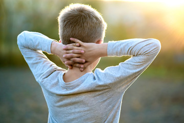 Wall Mural - Child boy standing outdoors on summer sunny day enjoying warm weather outside. Rest and wellness concept.