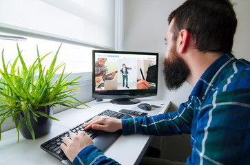 Man in front of computer with online courses website on the screen