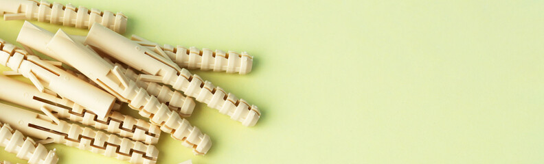 A pile of beige nylon dowels on a yellow background.Selective focus. Repair and construction. Keyboard layout. Banner