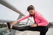 © Mego-studio - Athletic woman stretching legs before exercise.