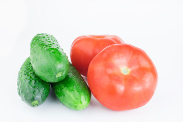 Cucumbers and tomatoes are isolated on a white background.