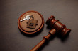 © burdun - Judge gavel and key chain in shape of two splitted part of house on wooden background. Concept of real estate auction or dividing house when divorce, division of property, real estate, law system.