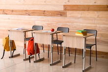Modern School Desks Near Wooden Wall