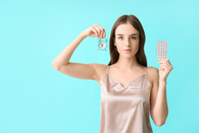 Young Woman With Birth Control Pills And Clock On Color Background