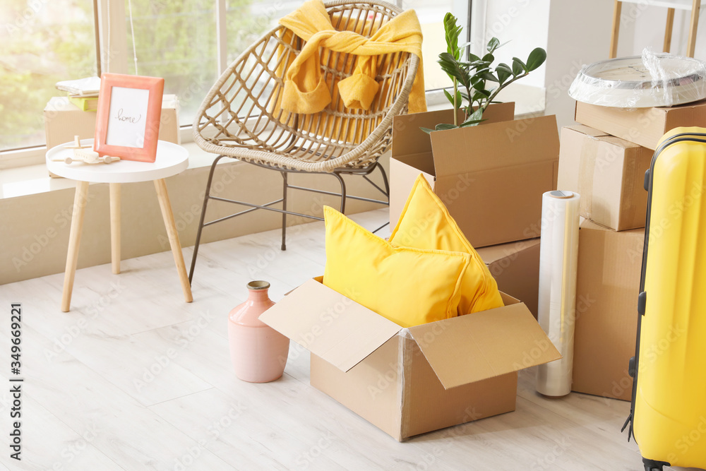 Cardboard boxes with belongings in new flat on moving day