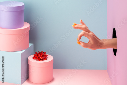 Fotografía Woman's hand showing an alright sign on blue and pink background