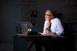 © Elnur - Old male employee working late at workplace