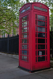 Fototapeta Londyn - Top of British red telephone box in London in front of trees
