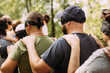 side view of close-up of blindfolded people. Man and woman Hold on to the shoulders of the person in front outdoor. Team building activity. Confidence in colleagues in the team.