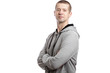 © Arsentyev Vladimir - The athletic self-confident athlete, a man in a hooded jacket, his arms crossed on his chest, turned sideways. A look into the camera. Isolated