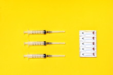 Three Disposable Syringes Are Located Opposite The Package With Medical Suppositories.