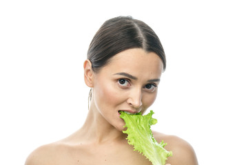 Wall Mural - portrait of a girl with clean skin without makeup with a leaf of green salad