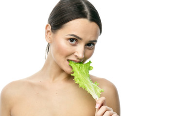 Wall Mural - portrait of a girl with clean skin without makeup with a leaf of green salad