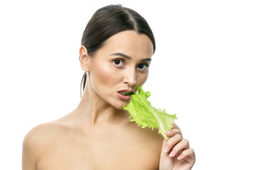 Wall Mural - portrait of a girl with clean skin without makeup with a leaf of green salad