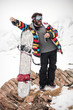 © guruXOX - Happy and positive snowboarder posing and enjoying outdoors, against a background of snowy peaks. Travel Lifestyle concept active leisure in the open air of winter sports. Sport in the winter mountain