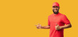 © Prostock-studio - Black Courier Man Pointing Fingers Aside Gesturing Thumbs-Up, Yellow Background