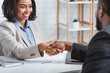 © Prostock-studio - African American hiring manager shaking hand of vacancy candidate during employment interview in office