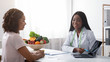 © Prostock-studio - Dietician consulting young lady at clinic, using laptop