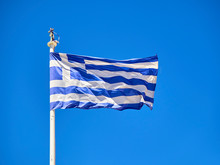 Official Flag Of Greece Waving On A Blue Sky.