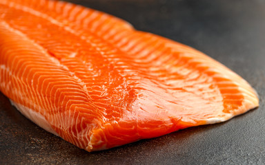 Raw salmon fillet on rustic table background