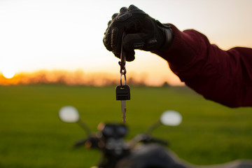 Wall Mural - man holding a dark transport key on a background of motorcycles