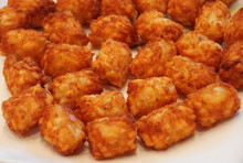Close Up Of The Fried Crispy Tator Tots On A White Plate