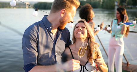 Wall Mural - Group of friends drinking, chatting and having a fun at outdoor party